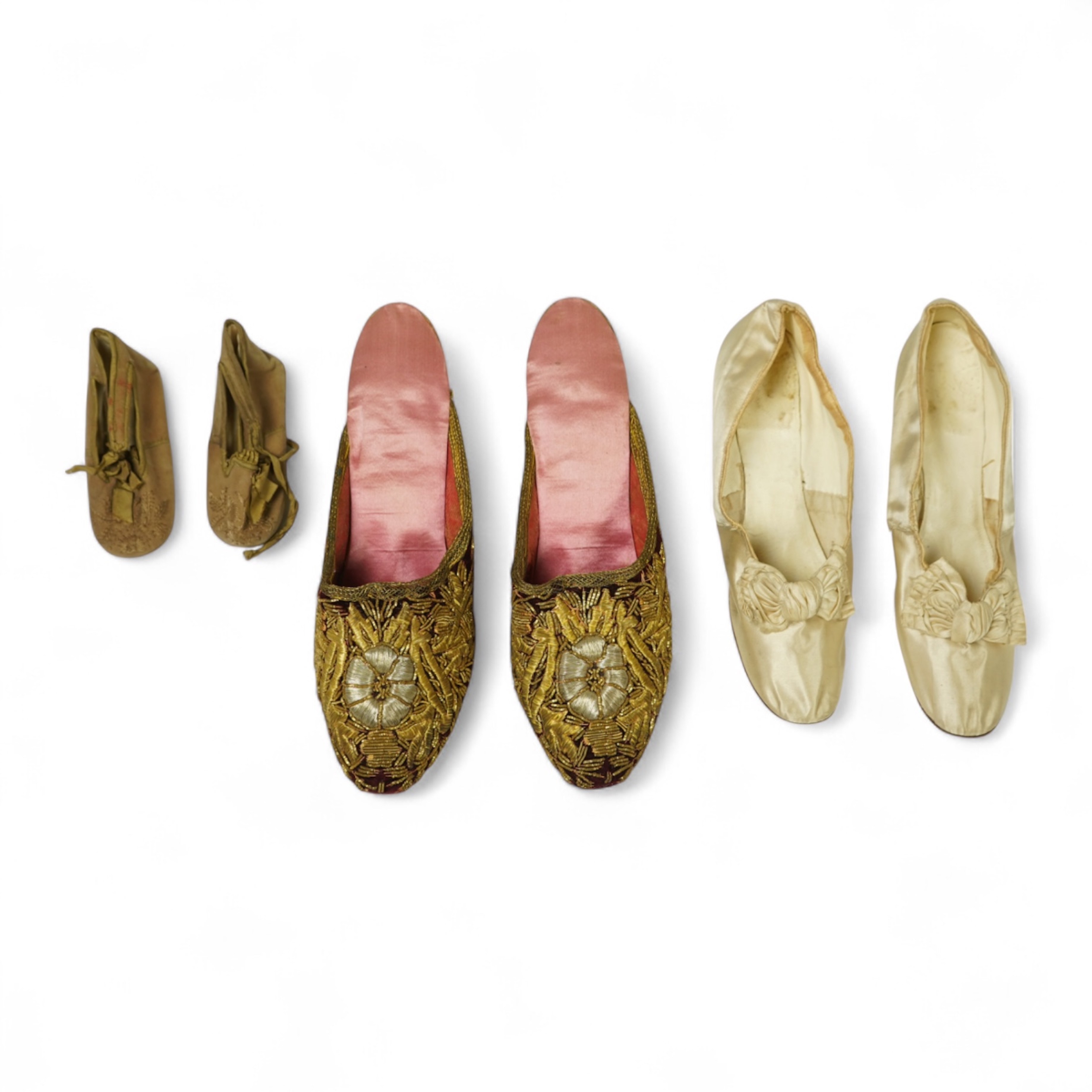 An unusual pair of Edwardian ladies red velvet and gold embroidered mules, a pair of 19th century ladies cream silk shoes and a pair of baby's embroidered suede shoes. Mules stamped 41at toe of sole. Condition - all thre